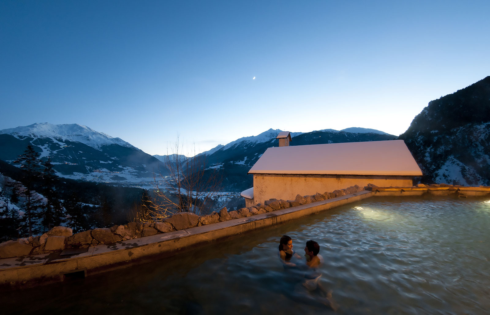 A girl under a water stream in the thermal baths